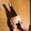 Une bouteille PAIRING 75 cl tenue au-dessus d'une table en bois