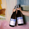 Deux bouteilles VIBING 75 cl tenues devant une toile peinte